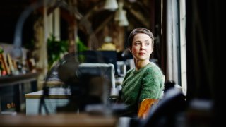 Businesswoman sitting at workstation looking out window