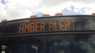 A Amber Alert warning is displayed on a transit bus destination sign.