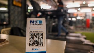 A man exercises in a gym near a barcode for Paytm, an Indian cellphone-based digital payment platform, in New Delhi on November 18, 2021.