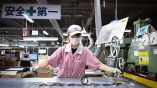 An employee checks gaskets after processing them in an automatic press machine at the Hamamatsu Gasket Co. factory in Hamamatsu, Shizuoka Prefecture, Japan, on Wednesday, Oct. 6, 2021.