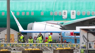 A person walks past an unpainted Boeing 737-8 MAX parked at Renton Municipal Airport adjacent to Boeing’s factory in Renton, Washington on January 25, 2024. 