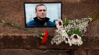 Flowers and a portrait of Russian opposition leader Alexei Navalny are seen following Navalny’s death, as people gather near the Russian embassy in Paris, France, February 16, 2024. 