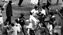 New York Yankees slugger Reggie Jackson, center, makes a run for the dugout after the final out and the Yankees' win of the World Series title, New York, October 18, 1977. Jackson led his team to an 8-4 victory by hitting three home runs in Game 6 of the championship. (AP Photo)