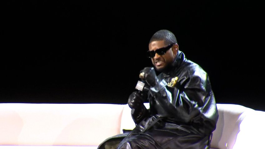 Usher at a press conference sitting on a couch