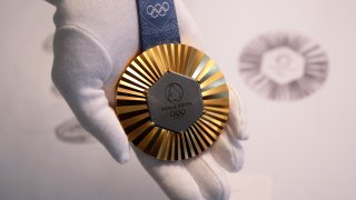 The Paris 2024 Olympic gold medal is presented to the press.