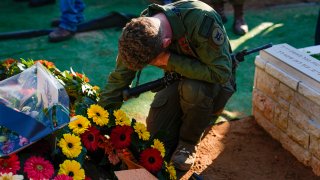 An Israeli solider mourns in grief over the grave of Staff sergeant Narya Belete.