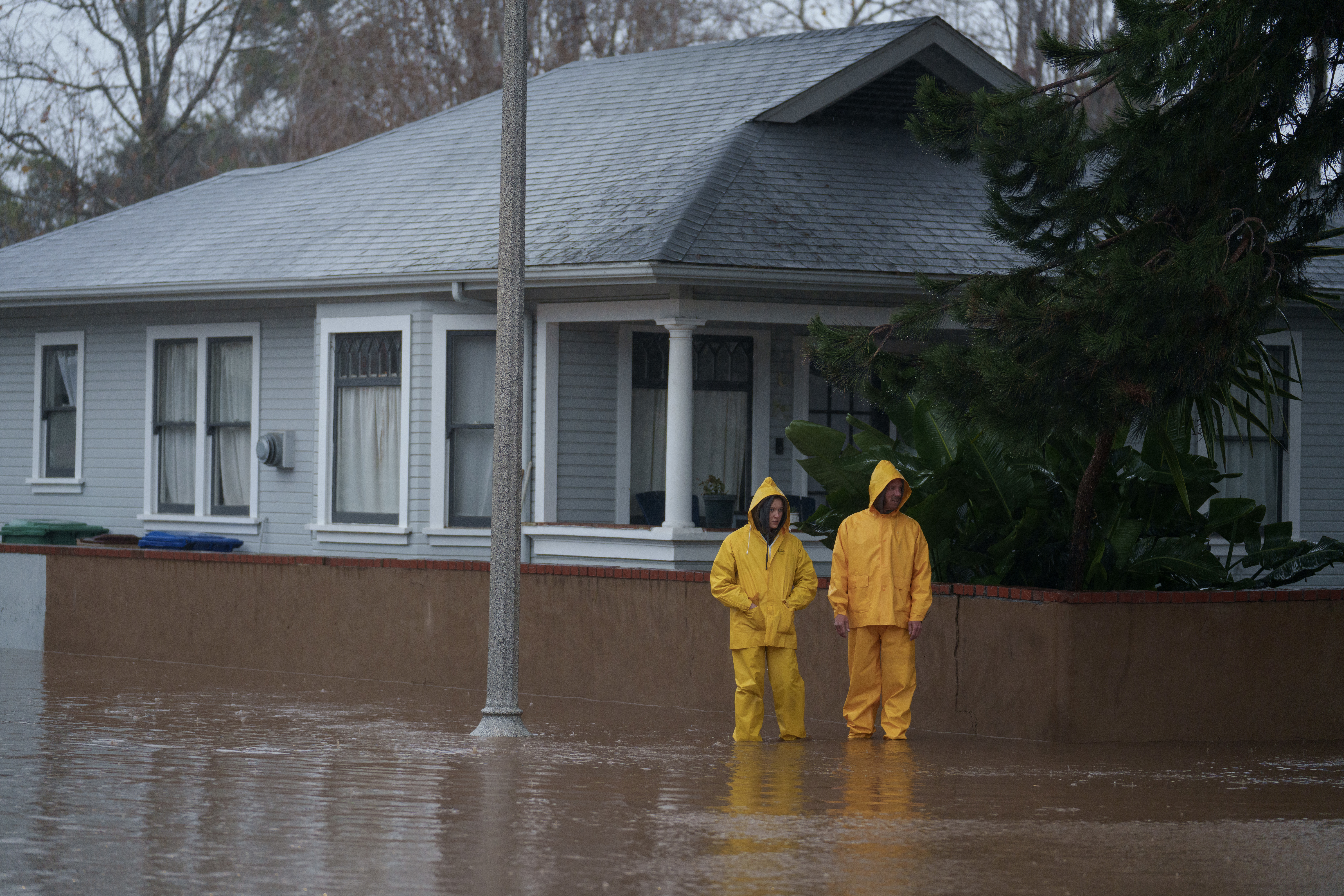 People stand in floodwater during a storm in Santa Barbara, California, US, on Sunday, Feb. 4, 2024. Hurricane-force winds whipped the seas off California, while heavy rains raised flood risks from San Francisco to San Diego, as another powerful Pacific storm arrived on the state’s doorstep. Photographer: Eric Thayer/Bloomberg via Getty Images