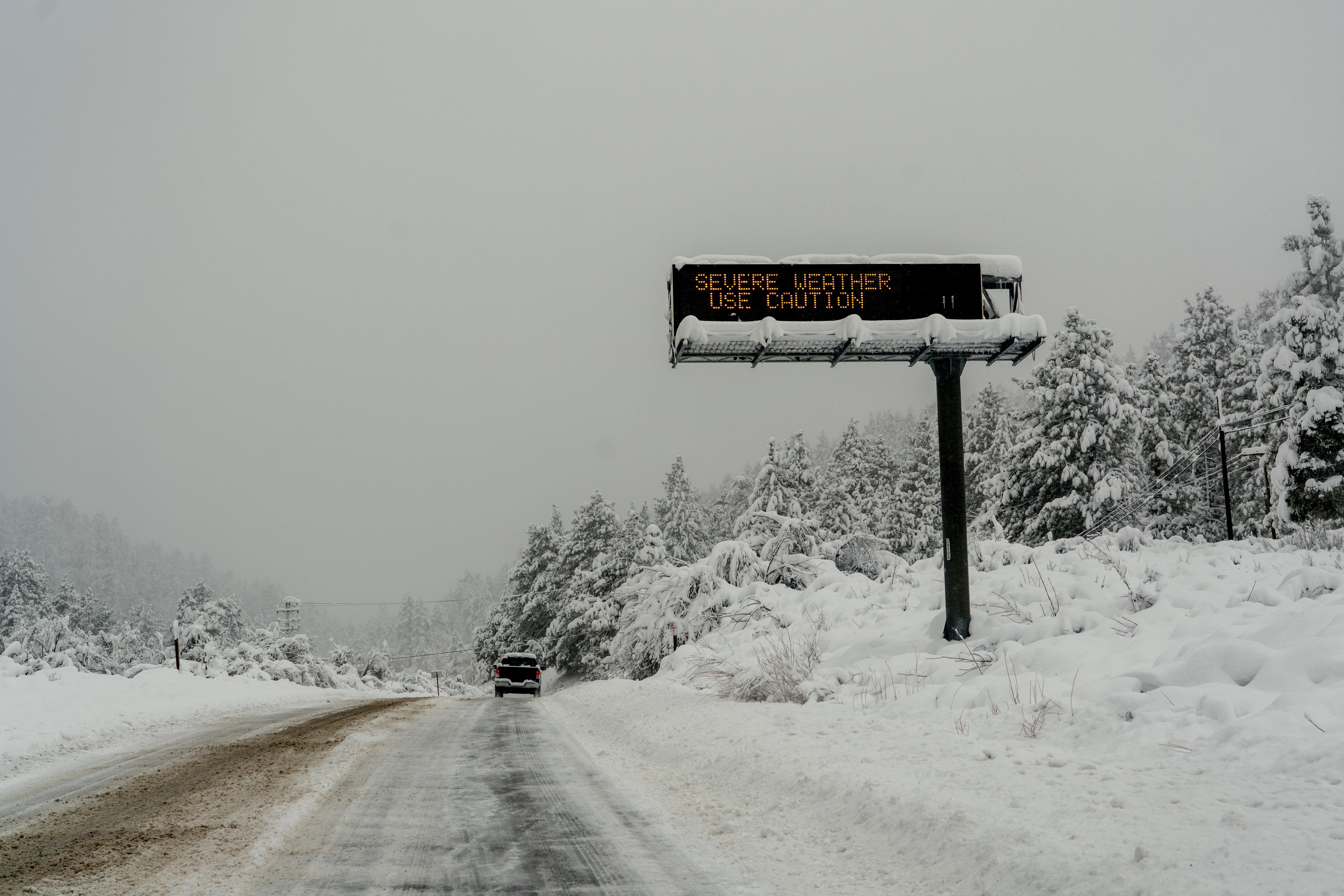 A sign cautions motorists of severe weather in the San Gabriel Mountains during a storm in Wrightwood, California, US, on Tuesday, Feb. 6, 2024. The wind-whipped storm that dropped an historic amount of rain on California this week killed two people and has caused as much as $11 billion in damage and economic losses. Photographer: Kyle Grillot/Bloomberg via Getty Images