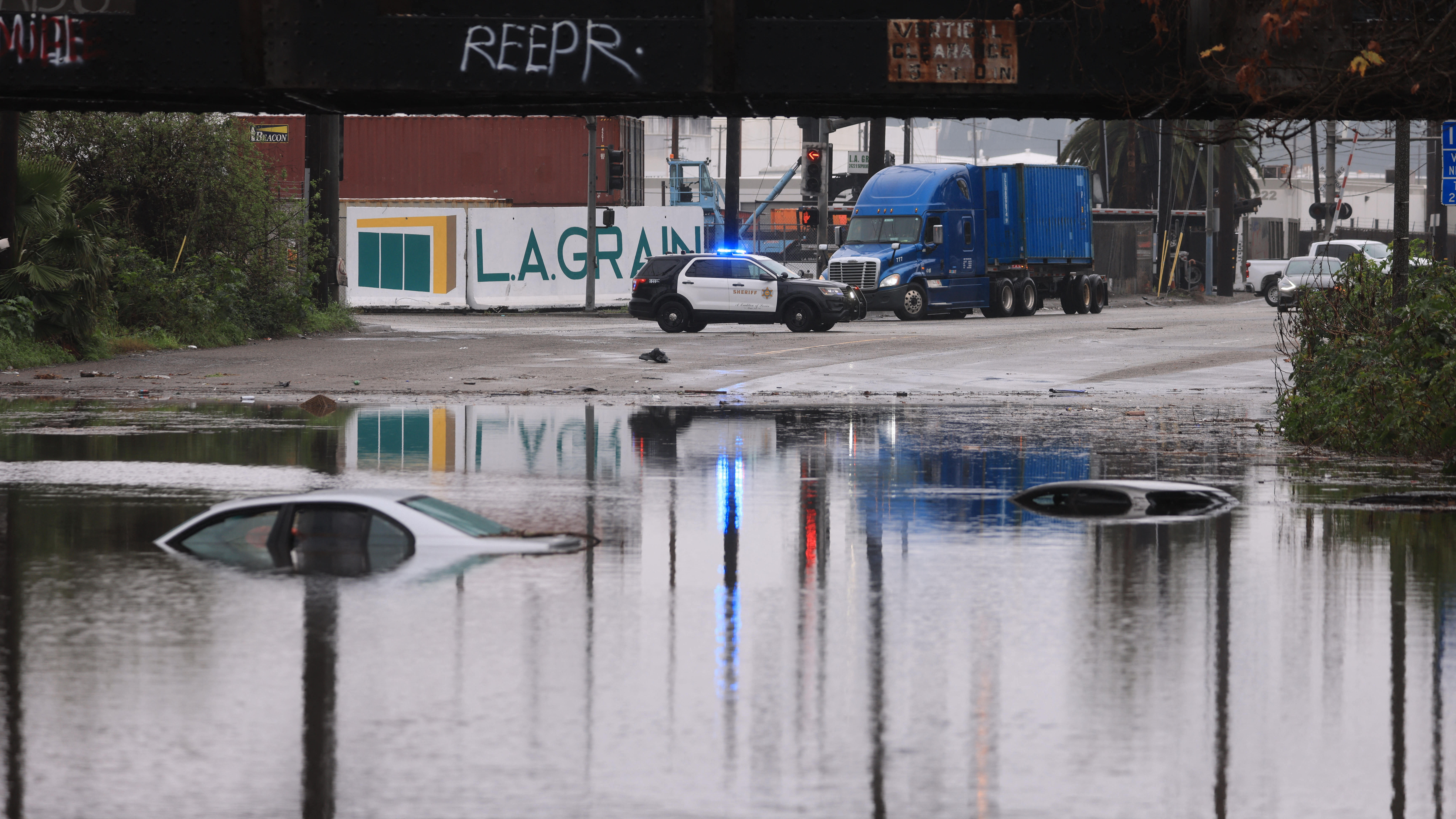 Cars sit partially submerged on a flooded road during a rain storm in Long Beach, California, on February 1, 2024. The US West Coast was getting drenched February 1, 2024 as the first of two powerful storms moved in, part of a “Pineapple Express” weather pattern that was washing out roads and sparking flood warnings. (Photo by David SWANSON / AFP) (Photo by DAVID SWANSON/AFP via Getty Images)