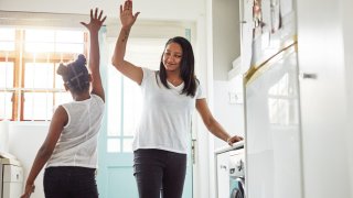 Shot of a mother and daughter high-fiving after finishing their chores