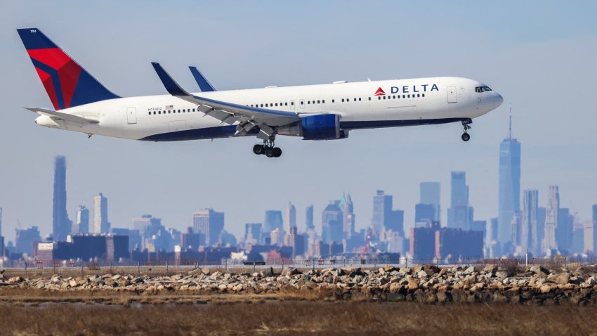 A Boeing 767 passenger aircraft of Delta Air Lines arrives from Dublin at JFK International Airport in New York as the Manhattan skyline looms in the background on Feb. 7, 2024.