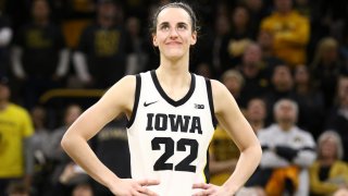 Guard Caitlin Clark #22 of the Iowa Hawkeyes listens as the crowd cheers after breaking the NCAA women’s all-time scoring record during the game against the Michigan Wolverines at Carver-Hawkeye Arena on February 15, 2024 in Iowa City, Iowa. 