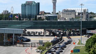 FILE - Cars wait in line to go through US customs at the Rainbow Bridge between Niagara Falls, New York
