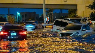 Cars drive in a flooded street following heavy rains in Dubai on April 17, 2024.
