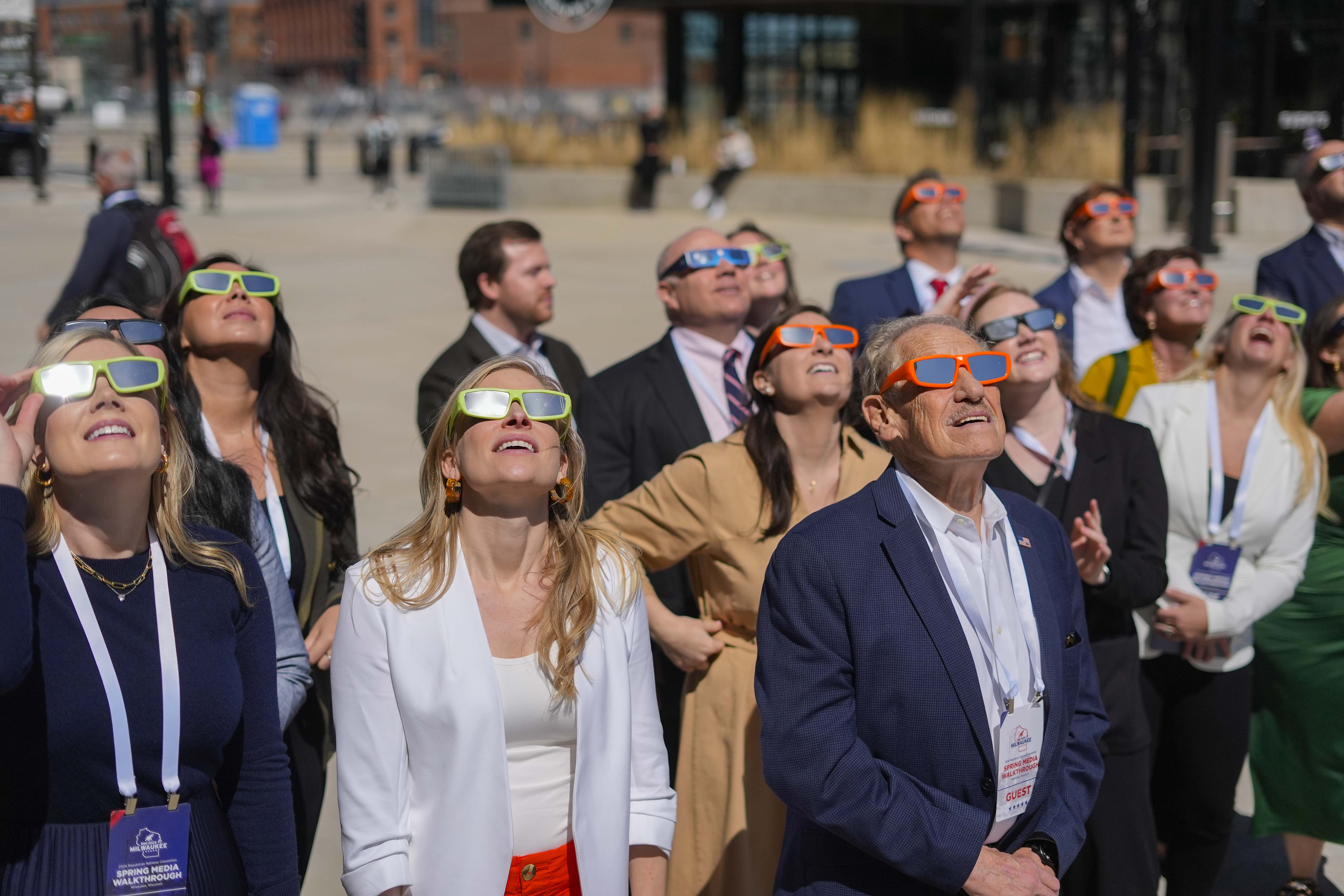 People gather to look on during a solar eclipse outside the Fiserv Forum Monday, April 8, 2024