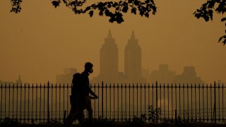 People walk in Central Park as smoke from wildfires in Canada cause hazy conditions in New York Cit