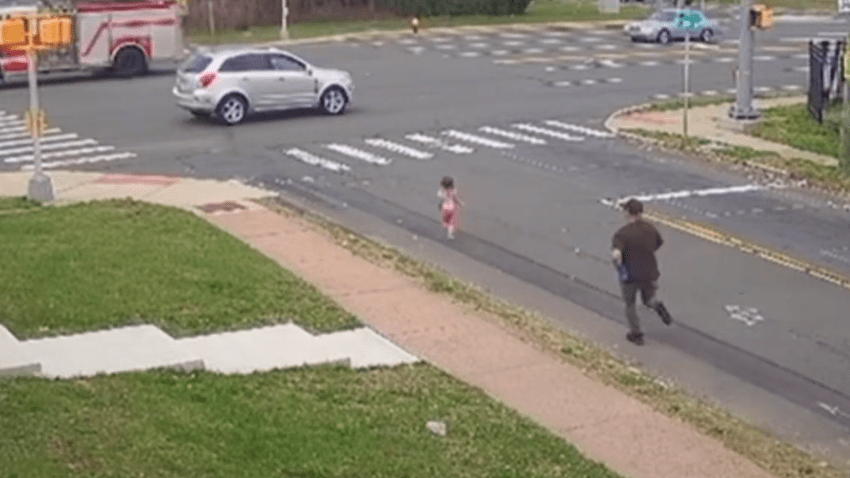 Screenshot of security video showing young girl running towards traffic