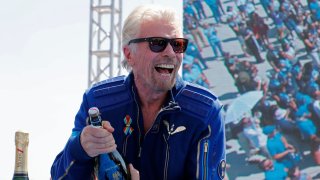 Billionaire entrepreneur Richard Branson prepares to spray champagne after flying with a crew in Virgin Galactic’s passenger rocket plane VSS Unity to the edge of space at Spaceport America near Truth or Consequences, New Mexico, U.S., July 11, 2021.