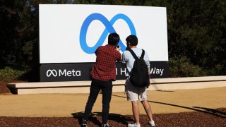 People take photos of the new “Meta” sign at the One Hacker Way in Menlo Park, as Facebook changes its company name to Meta in California, on October 28, 2021.