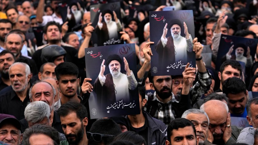 People hold up posters of President Ebrahim Raisi during a mourning ceremony for him at Vali-e-Asr square in downtown Tehran, Iran, Monday, May 20, 2024.