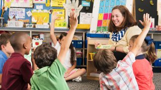Teacher and students using flash cards in classroom