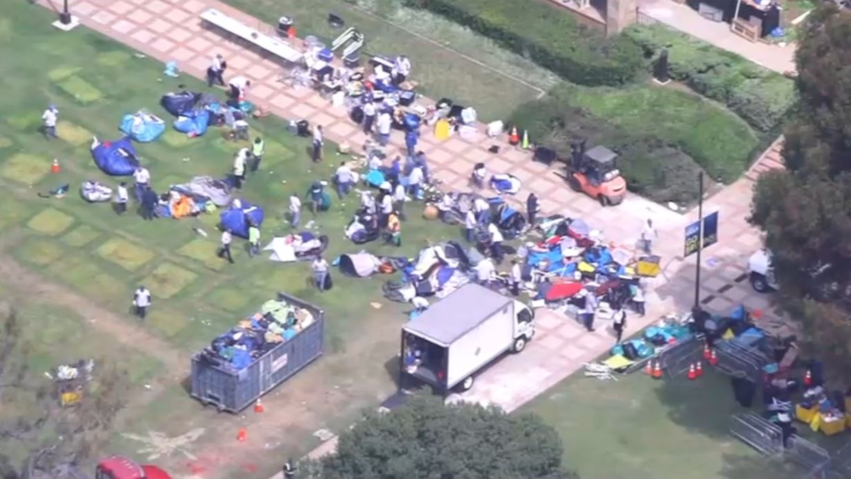 Cleanup crews remove items at a UCLA protest encampment Thursday May 2, 2024.