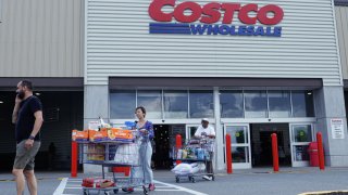 Customers exit a Costco store in Teterboro, New Jersey, June 28, 2023.