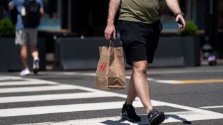 A shopper carries an H&M bag in the Georgetown neighborhood of Washington, DC, US, on Thursday, May 30, 2024. 