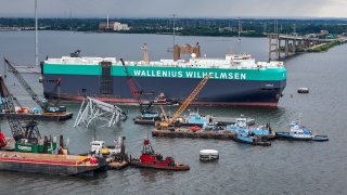 The vehicle carrier Tosca passes through an open section of the Federal channel as crane barges continue work on clearing the debris from the Francis Scott Key Bridge more than two months after the catastrophic collapse. 