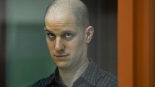 Wall Street Journal reporter Evan Gershkovich stands in a glass cage in a courtroom in Yekaterinburg, Russia.