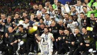 Real Madrid's Spanish defender Nacho Fernandez (C) and Real Madrid's players lift the trophy to celebrate their victory at the end of the UEFA Champions League
