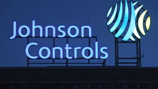 The logo of Johnson Controls stands over a production plant