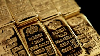 An employee handles one kilogram of gold bullions at the YLG Bullion International Co. headquarters in Bangkok, Thailand, on Friday, Dec. 22, 2023.