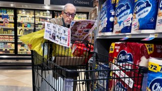 FILE - A shopper scans coupons in a grocery store in Washington, D.C., on May 23, 2024. 