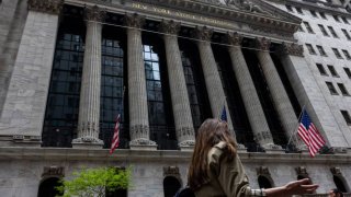 Pedestrians walk along Wall Street near the New York Stock Exchange (NYSE) in New York, US, on Thursday, May 16, 2024. 