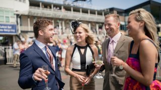 Two young adult couples enjoying a day at the races. Two couples enjoying a drink at the races.