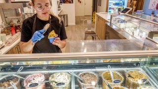 A server scooping ice cream at the Freddo Gelato Shop in Miami Beach, Florida.