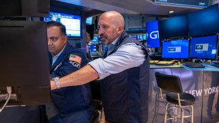 Traders work on the floor of the New York Stock Exchange (NYSE) as a picture of Vice President Kamala Harris is displayed on a television screen on July 22, 2024 in New York City. 