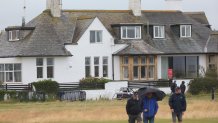 Spectators walk past "Blackrock house" that is listed for sale near the second and 16th holes at Royal Troon golf club, venue for the British Open Golf Championships, in Troon, Scotland, Tuesday, July 16, 2024. Royal Troon has some unique aspects but maybe most curious is the private house that sits in the middle of the championship course and has views of five holes. (AP Photo/Scott Heppell)