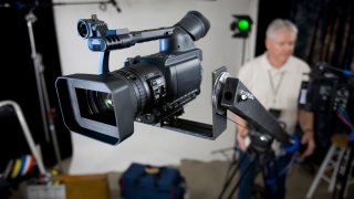 Camera operator raises the jib for a camera move while watching the monitor