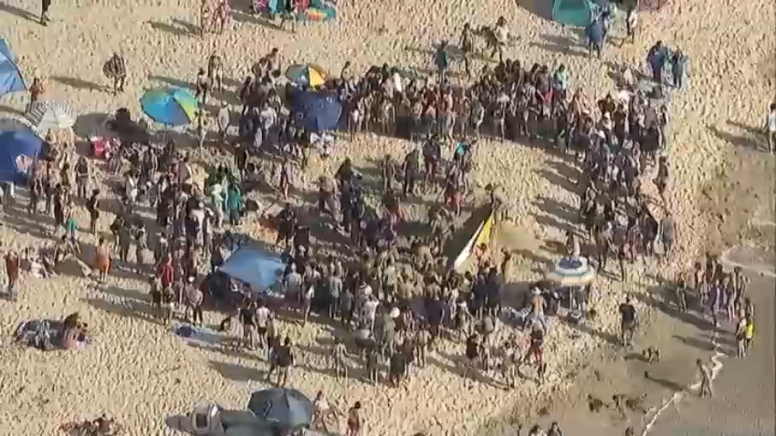 The crowd in Mission Beach, where San Diego Lifeguards worked to free a teen girl who was stuck in the sand on July 16, 2024.