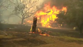 Flames from a Butte County wildfire engulf a structure Wednesday. (July 3, 2024)