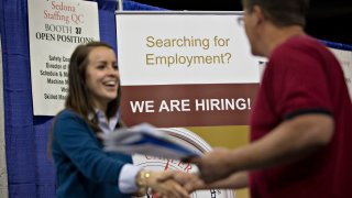 A job seeker, right, shakes the hand of a recruiter during the Quad Cities career fair in Moline, Illinois, U.S., on Wednesday, Oct. 14, 2015.