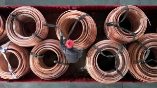 A worker tying copper wire rods before loading them onto a truck in Huai’an, in China’s Jiangsu Province.