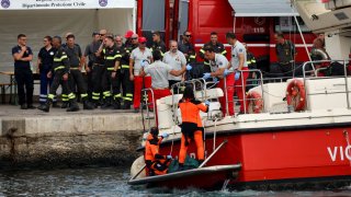 Rescue personnel transport a body bag as they operate at a port to search for the missing, including British entrepreneur Mike Lynch, after a luxury yacht sank off the coast of Porticello, near the Sicilian city of Palermo, Italy, August 21, 2024. 