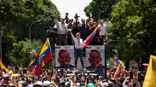 Opposition leader Maria Corina Machado holds a national flag while waving to supporters as she arrives for a rally in Caracas, Venezuela, Saturday, Aug. 3, 2024.