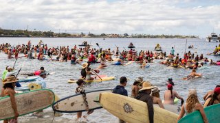 Hundreds of surfers paddle out into the waters of Hanakaoʻo Park as part of the ceremony marking the one-year anniversary of the Lahaina wildfire on Thursday, Aug. 8, 2024, in Lahaina, Hawaii.