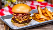 Hungry Bear Barbecue Jamboree - Smoked Angus Beef Burger and Pulled Pork with American cheese, golden aioli, pickled red onions, bread and butter pickles, and crispy onions served with beer-battered fries.
 (Disneyland Resort/David Nguyen)