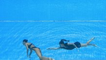 TOPSHOT - USA's coach Andrea Fuentes (R) swims to recover USA's Anita Alvarez (L), from the bottom of the pool during an incident in the women's solo free artistic swimming finals, during the Budapest 2022 World Aquatics Championships at the Alfred Hajos Swimming Complex in Budapest on June 22, 2022. (Photo by Oli SCARFF / AFP) (Photo by OLI SCARFF/AFP via Getty Images)