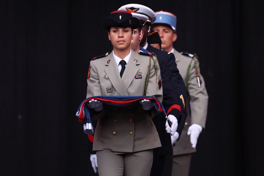 France's national flag enters the stadium carried by members of several corps